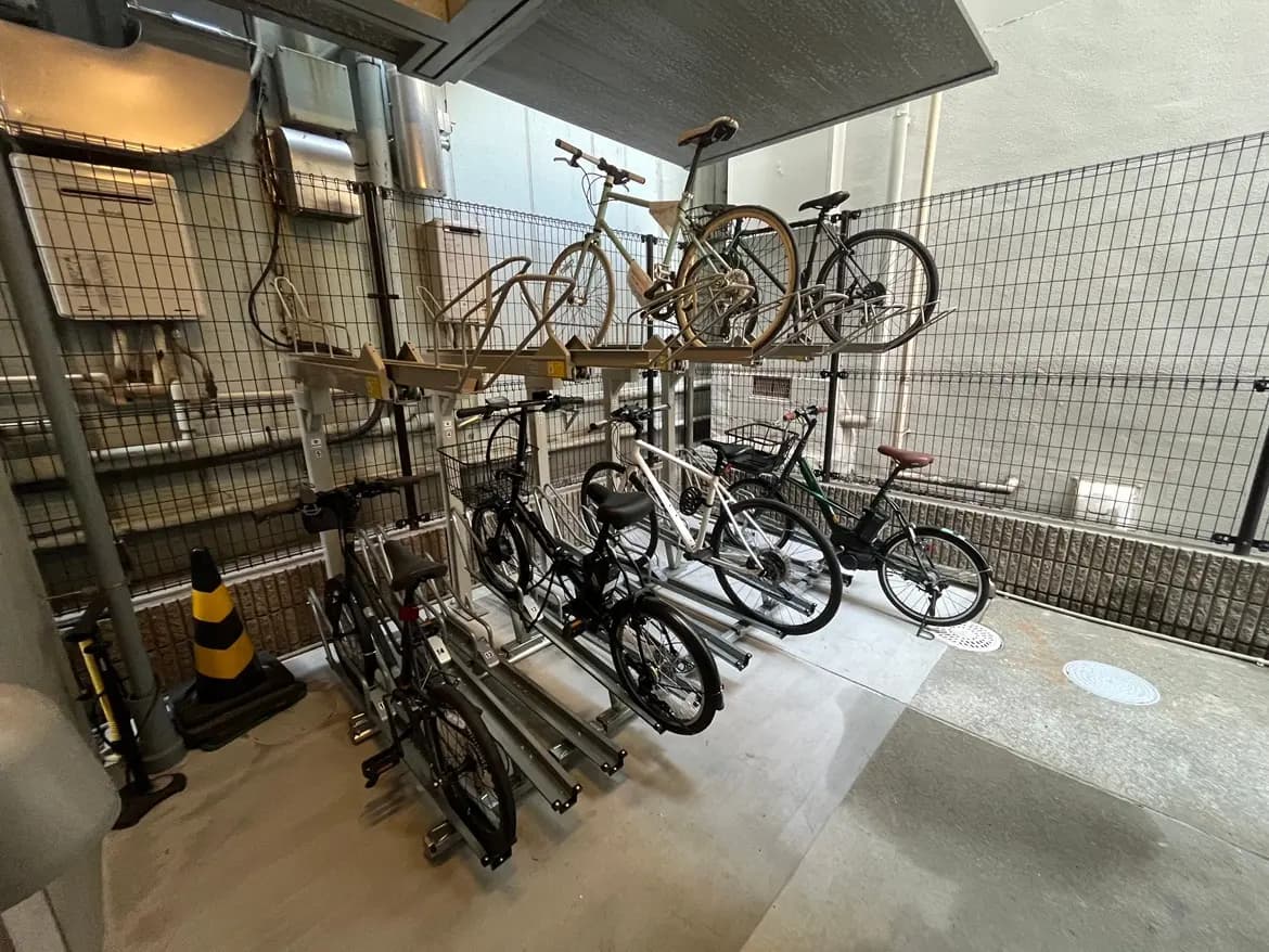 - 自転車用の収納スペース、上段に配置された自転車と下段に並んだ複数の自転車がある屋内の駐輪場