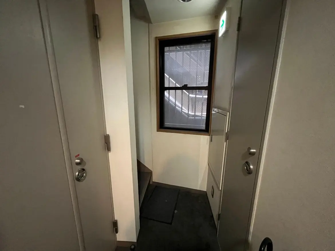 - クローゼットと階段のある狭い廊下、明るい窓がありシンプルな内装のインテリア