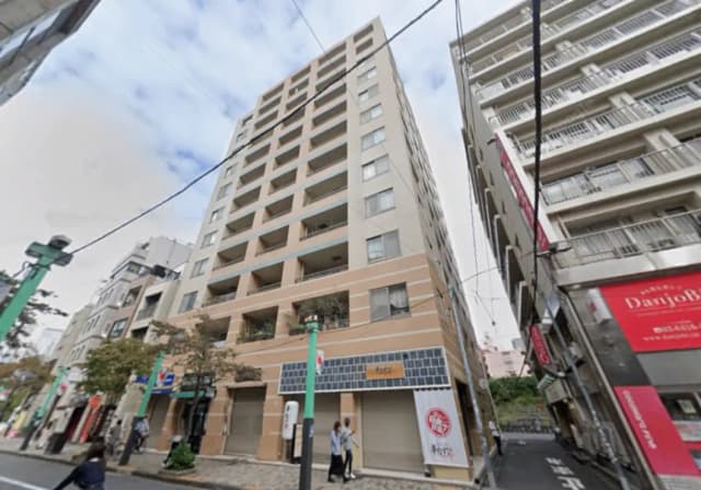 - 商業エリアに位置する現代的な複合施設、広い窓とバルコニーを持つ建物が通りに面している様子