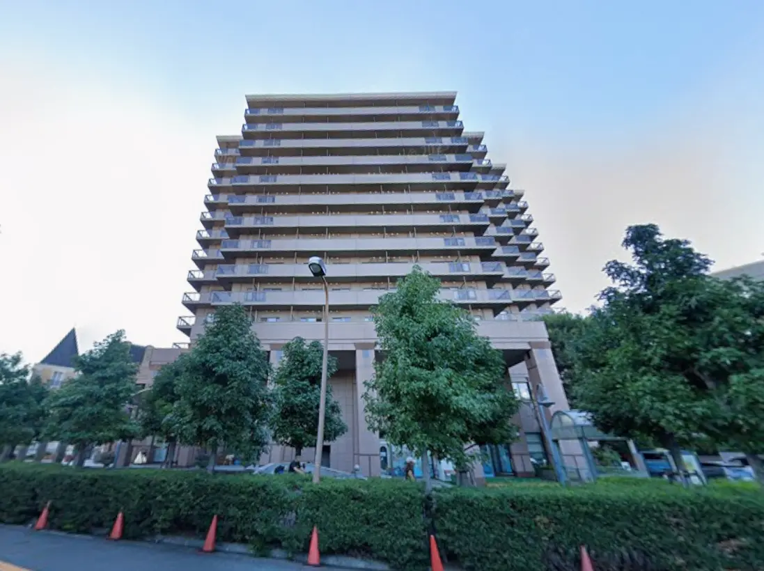現代的なデザインの11階建てマンション、周囲に緑の木々と整備された景観の外観