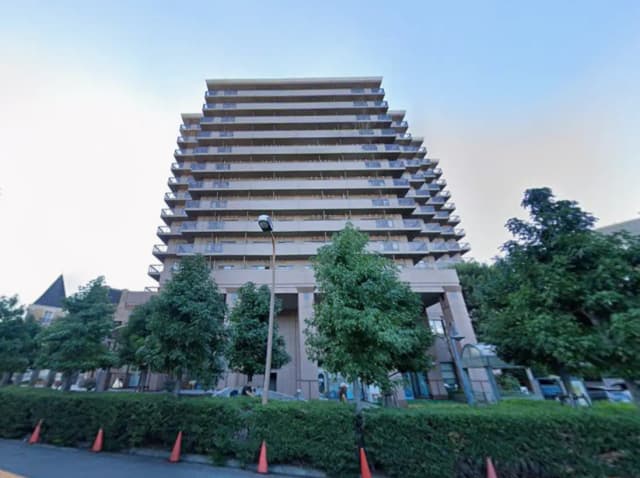 現代的なデザインの11階建てマンション、周囲に緑の木々と整備された景観の外観