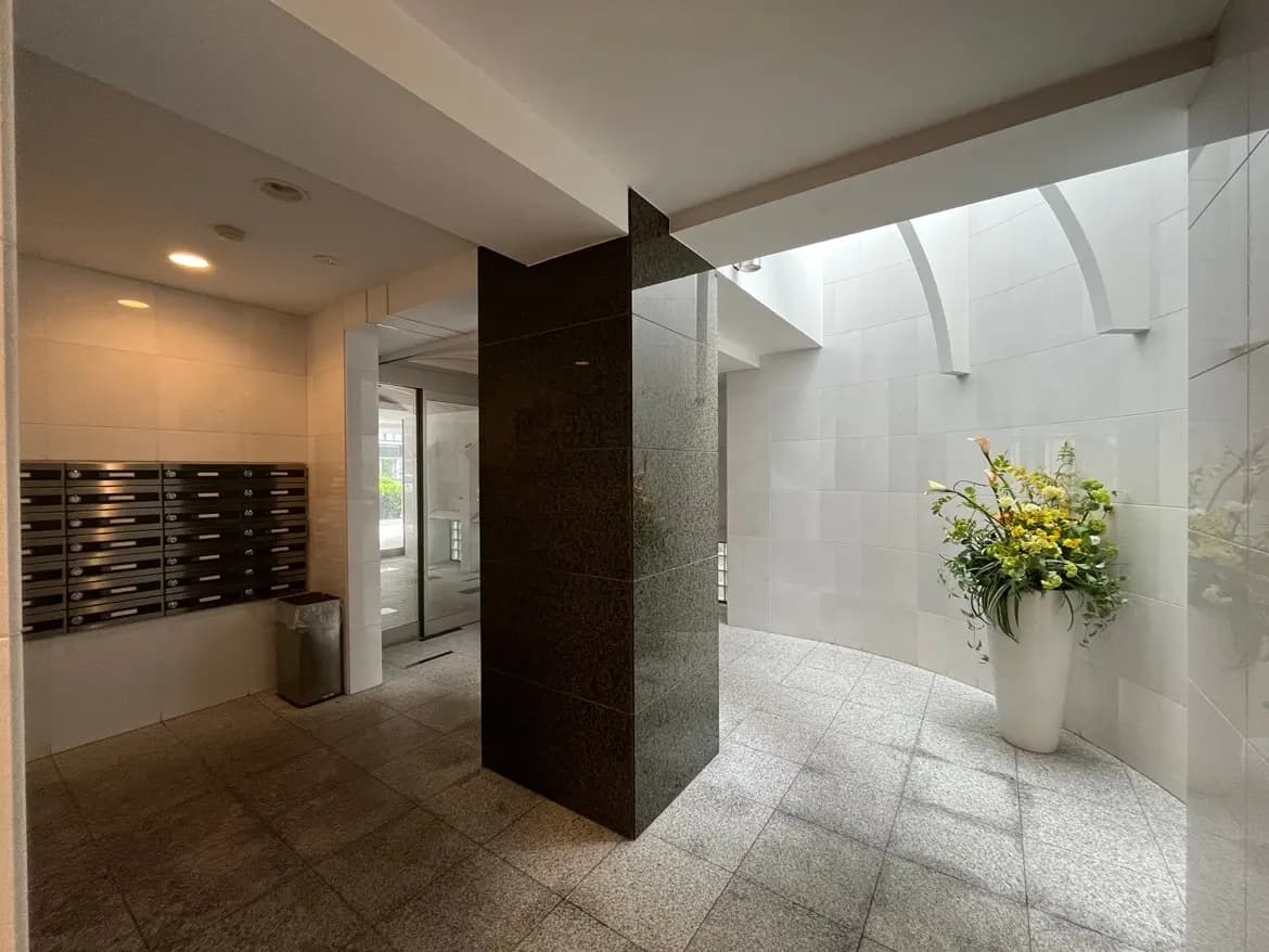 - シンプルでモダンなエントランスホール、郵便受けと観葉植物が配置された明るいインテリアデザイン