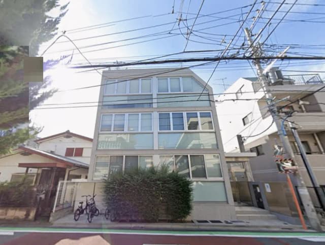 - 現代的な外観の三階建て住宅、広い窓と周辺の緑、電線が交錯する街並み