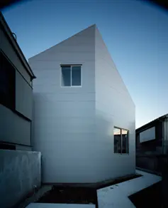 - 角が特徴的なモダンな住宅外観、シンプルなデザインと大きな窓が印象的な新しい建築物