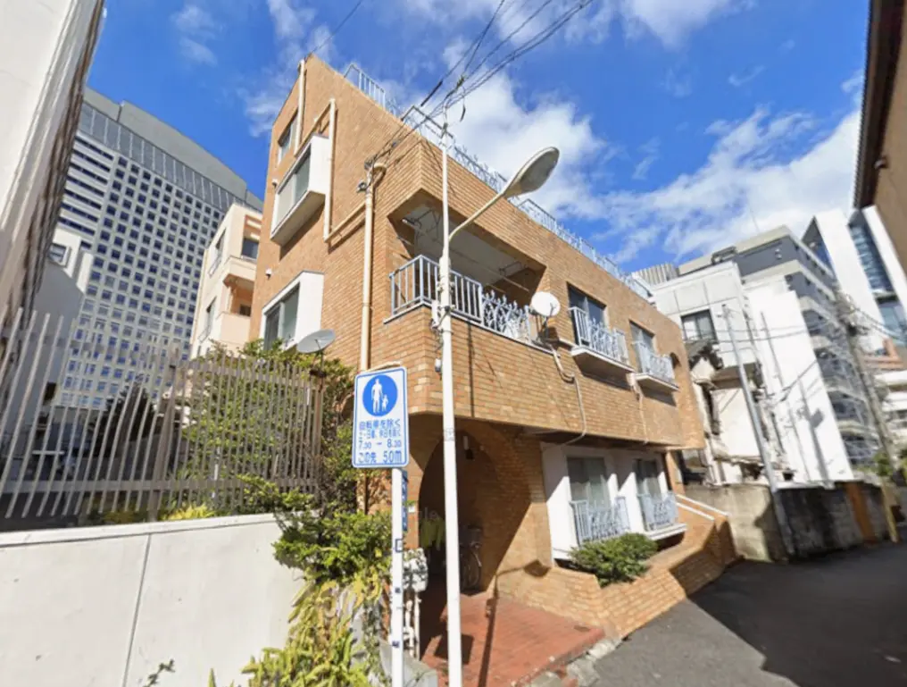 - 都市の中のレトロなレンガ造りのアパートメント、隣接する高層ビルとの対比が特徴的な外観