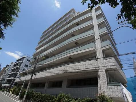 現代的なデザインのマンション、白い外壁と広いバルコニー、青空を背景にした印象的な外観