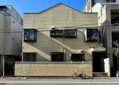 - モダンなデザインの外観を持つ住宅、角の窓が特徴的で自転車が置かれた街並みの一コマ