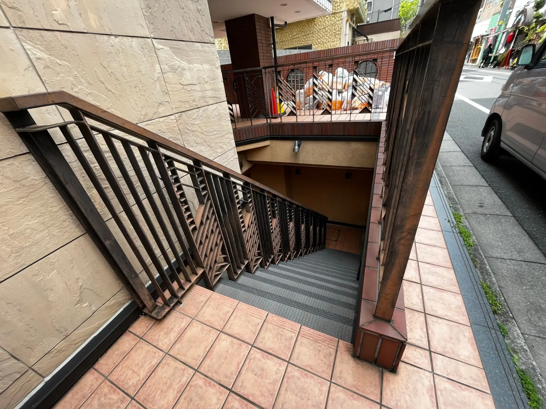 建物の外階段、茶色の手すり、ピンクタイルのステップ、都市の環境