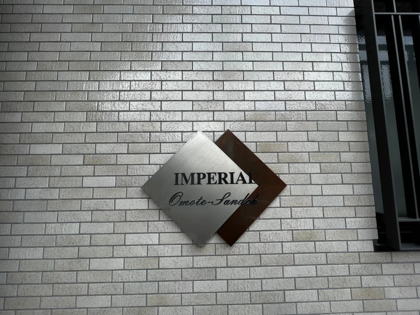 白いレンガ壁に取り付けられた「IMPERIAL Omote-Sando」の看板