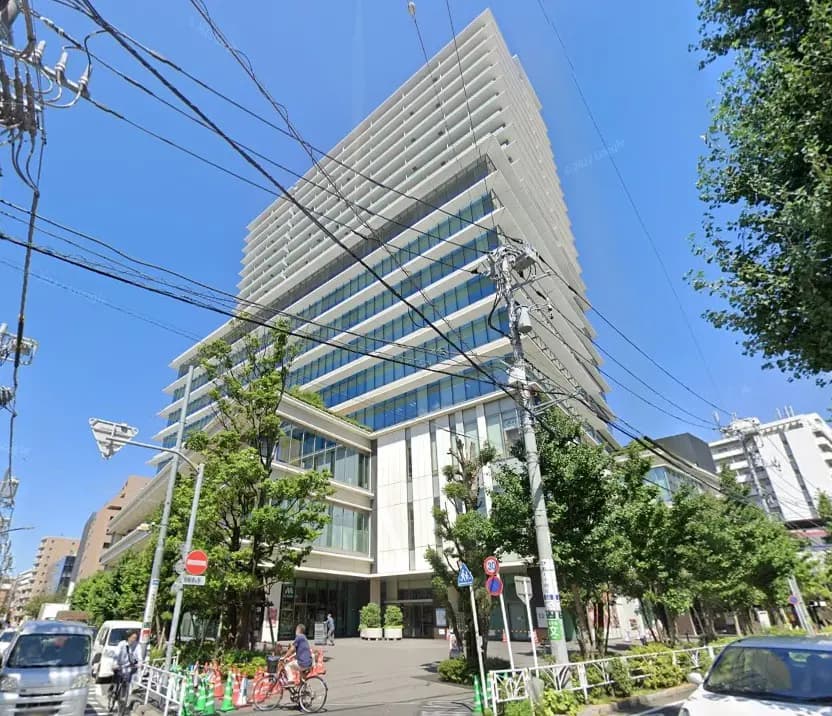 現代的なデザインのオフィスビル、通りに面していて周囲に緑がある都市風景
