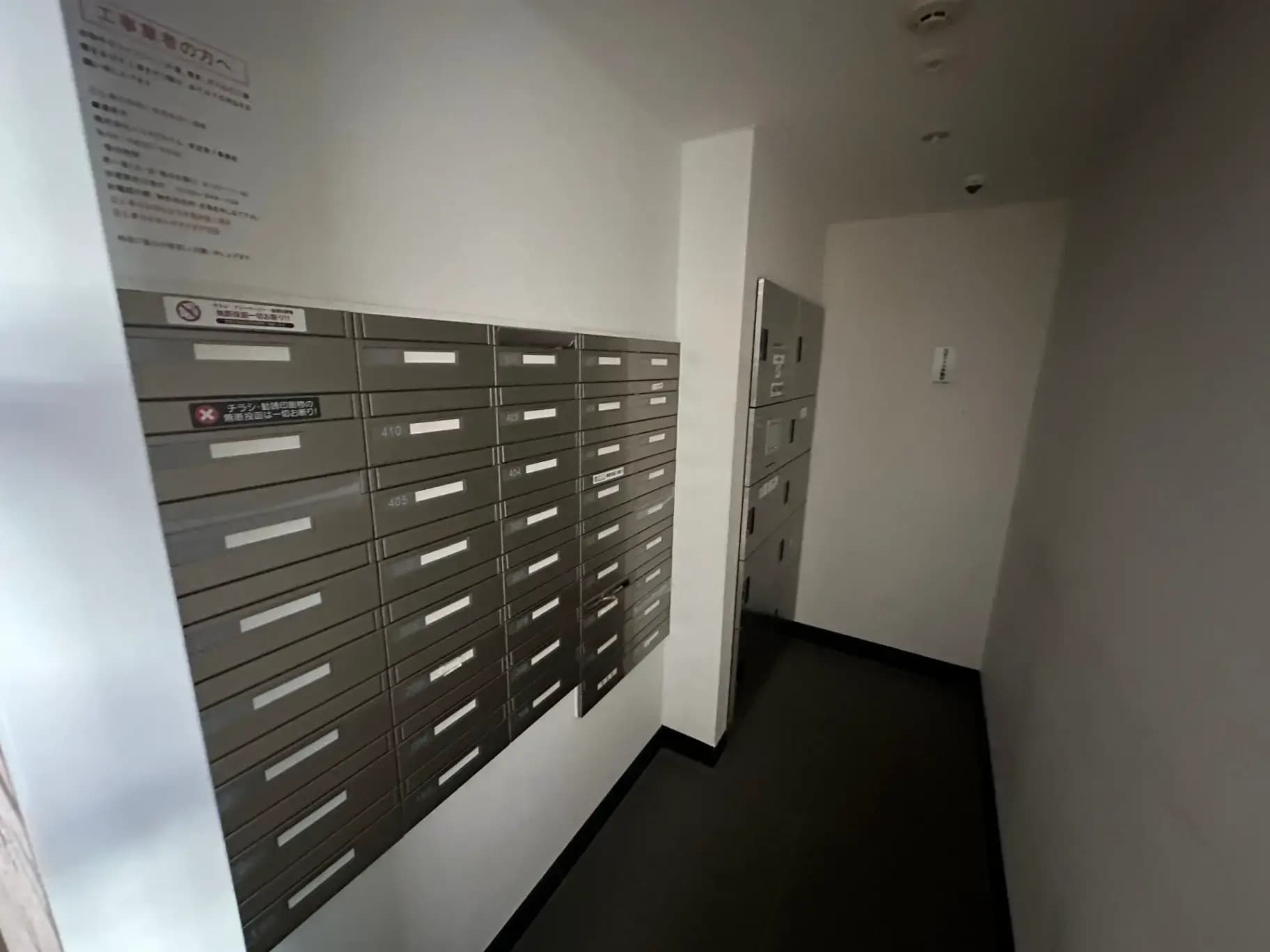 きれいに整理された郵便受けが並ぶマンションのエントランスホール
