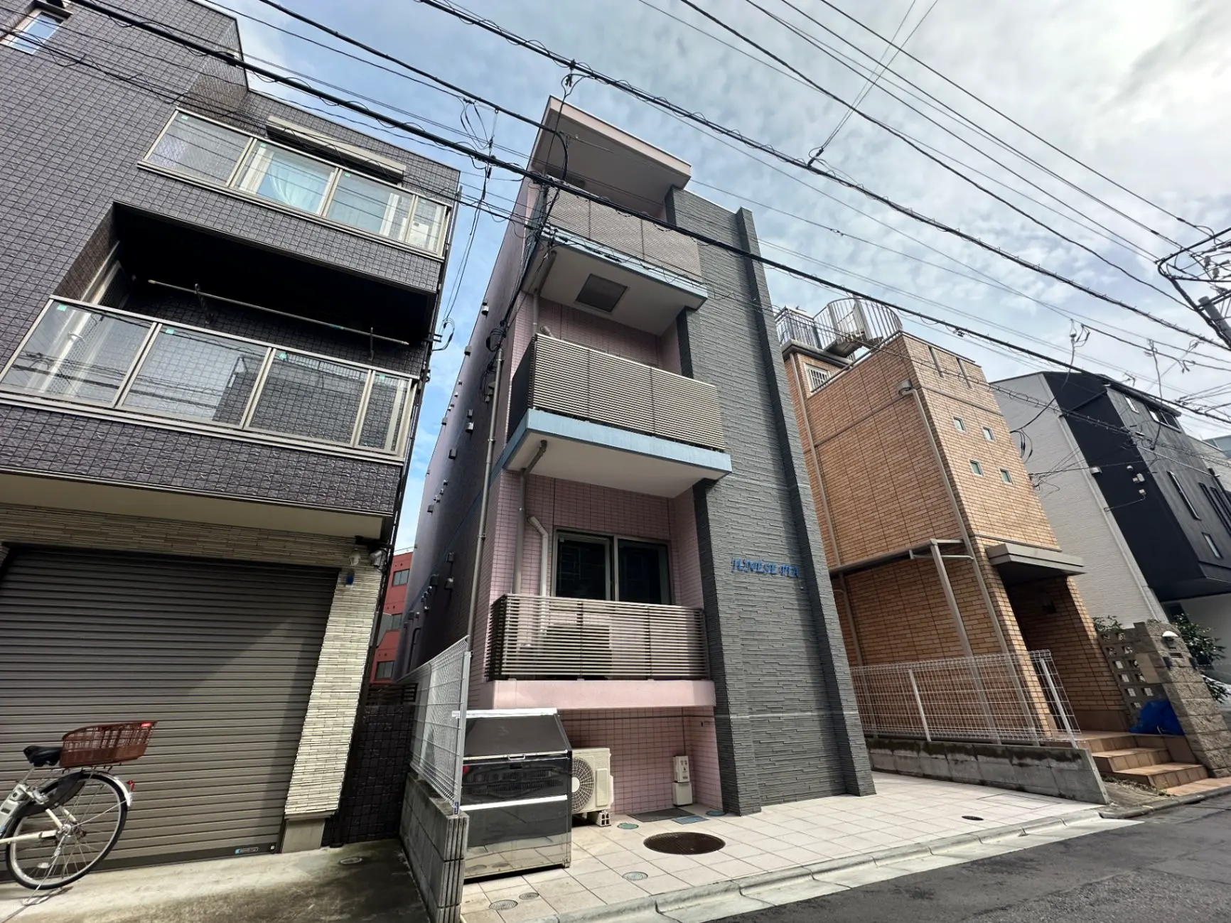 都市の狭小住宅、現代風の外観デザイン、日本の街並みに溶け込む住宅街のアパート