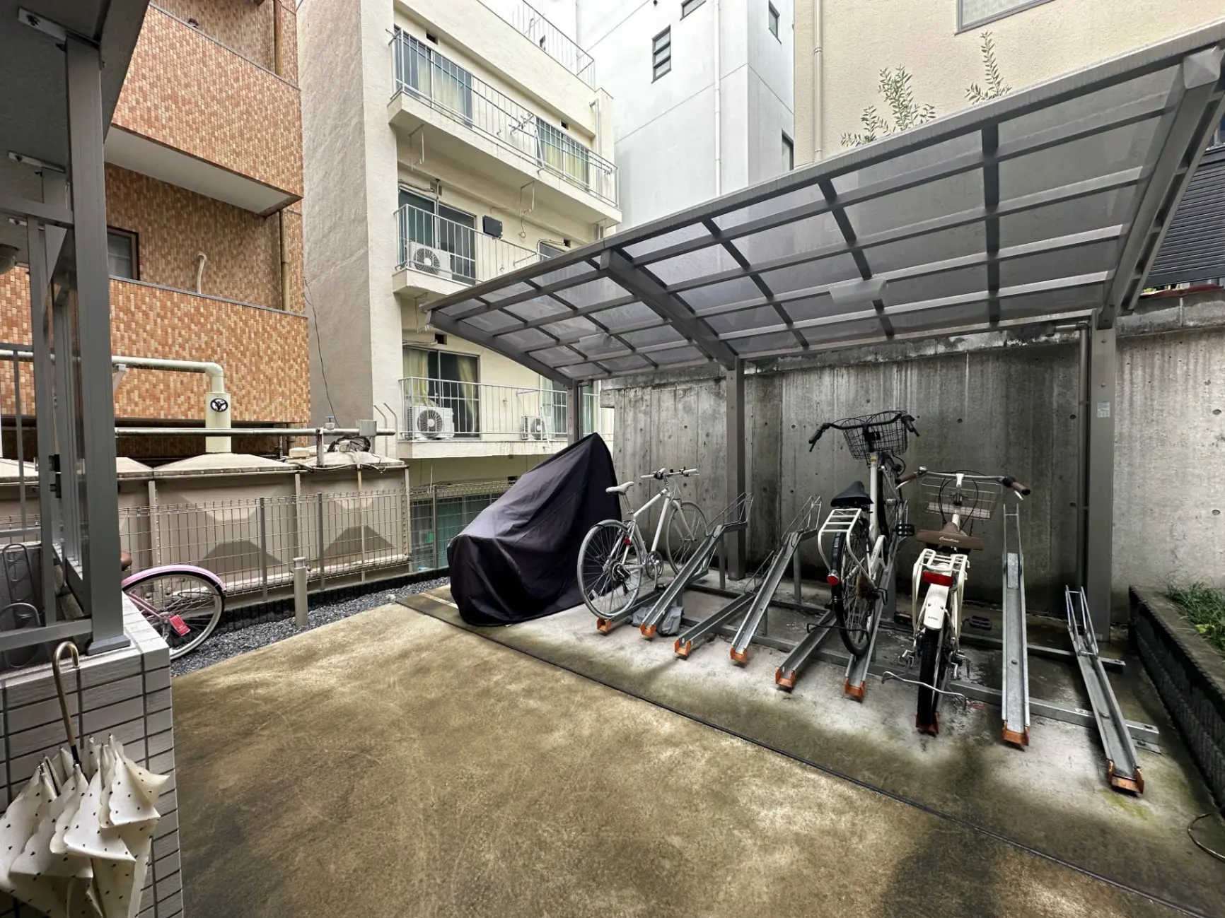 日本のマンションの駐輪場、雨よけの屋根付き、自転車が並んでいる光景