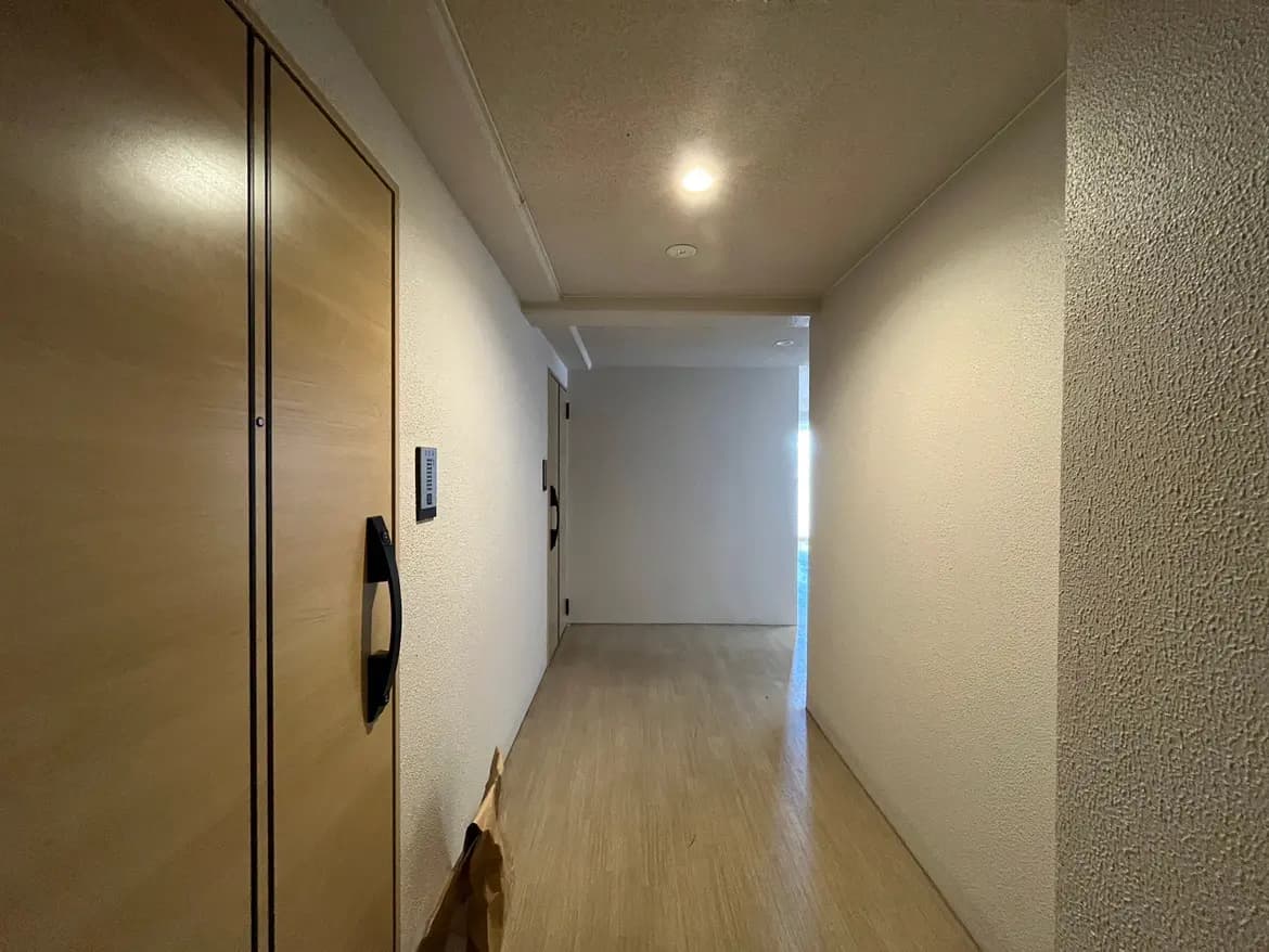 - 明るい光が差し込む広々とした廊下、木製のドアとシンプルな内装、エレガントなデザインの壁面