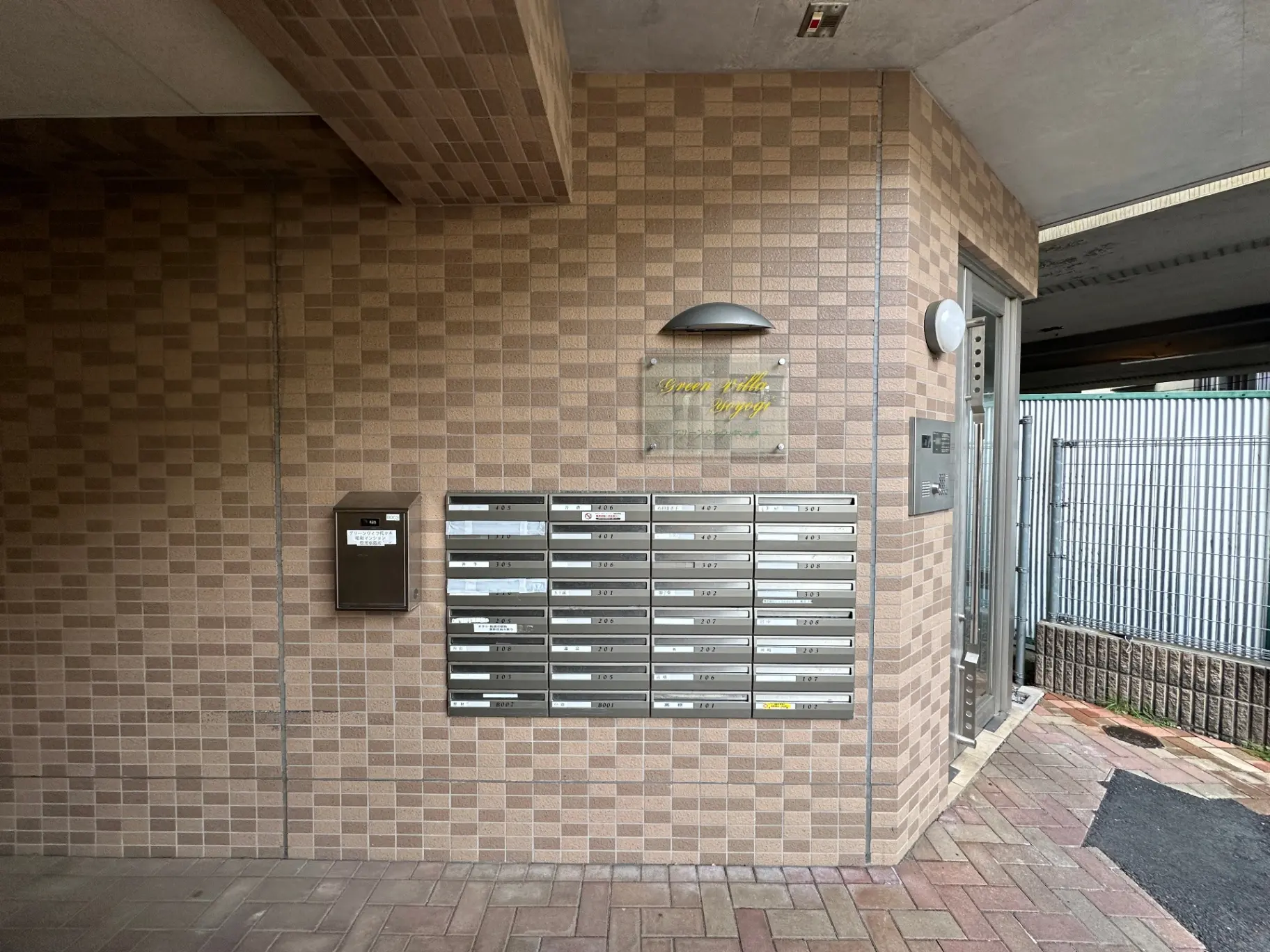 アパートのエントランス、モザイクタイルの壁、多数の郵便受け、インターホン設置