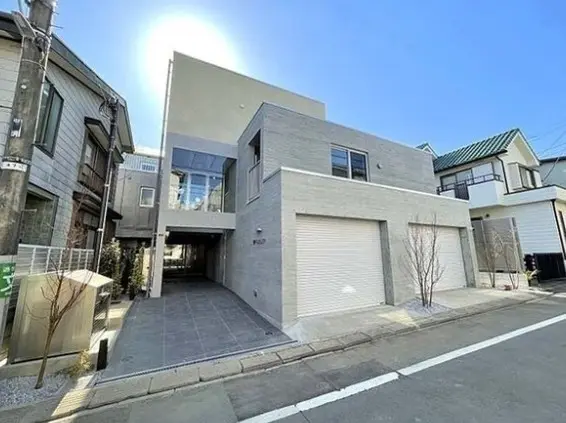 現代的な外観の都市型住宅、グレーの外壁とガレージがあるシンプルなデザイン