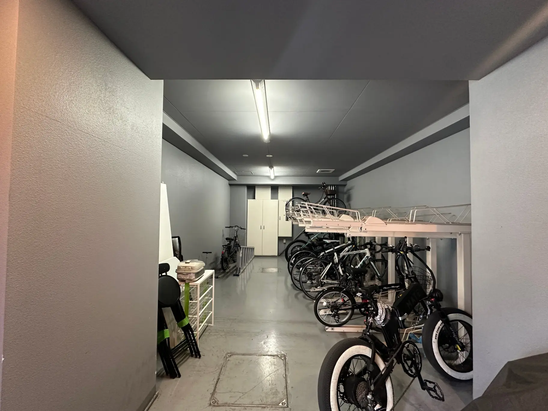 清潔で整理された自転車駐輪スペース、壁掛けラックに並ぶ様々なサイズの自転車とヘルメット