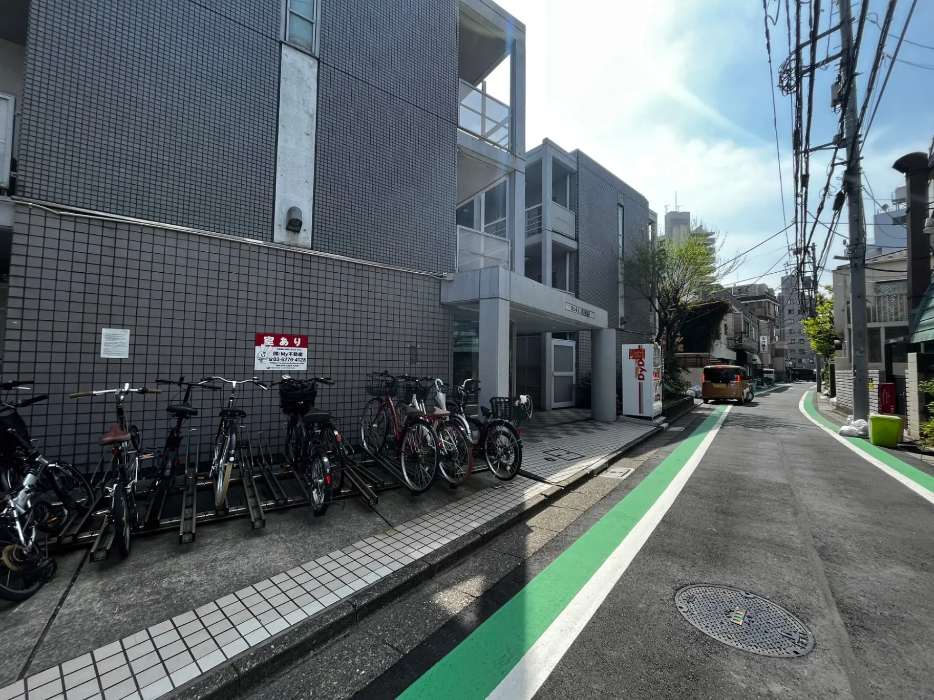 日本の都市の自転車駐輪場、ビルの前に整然と並ぶ複数の自転車、晴天の下の都市風景