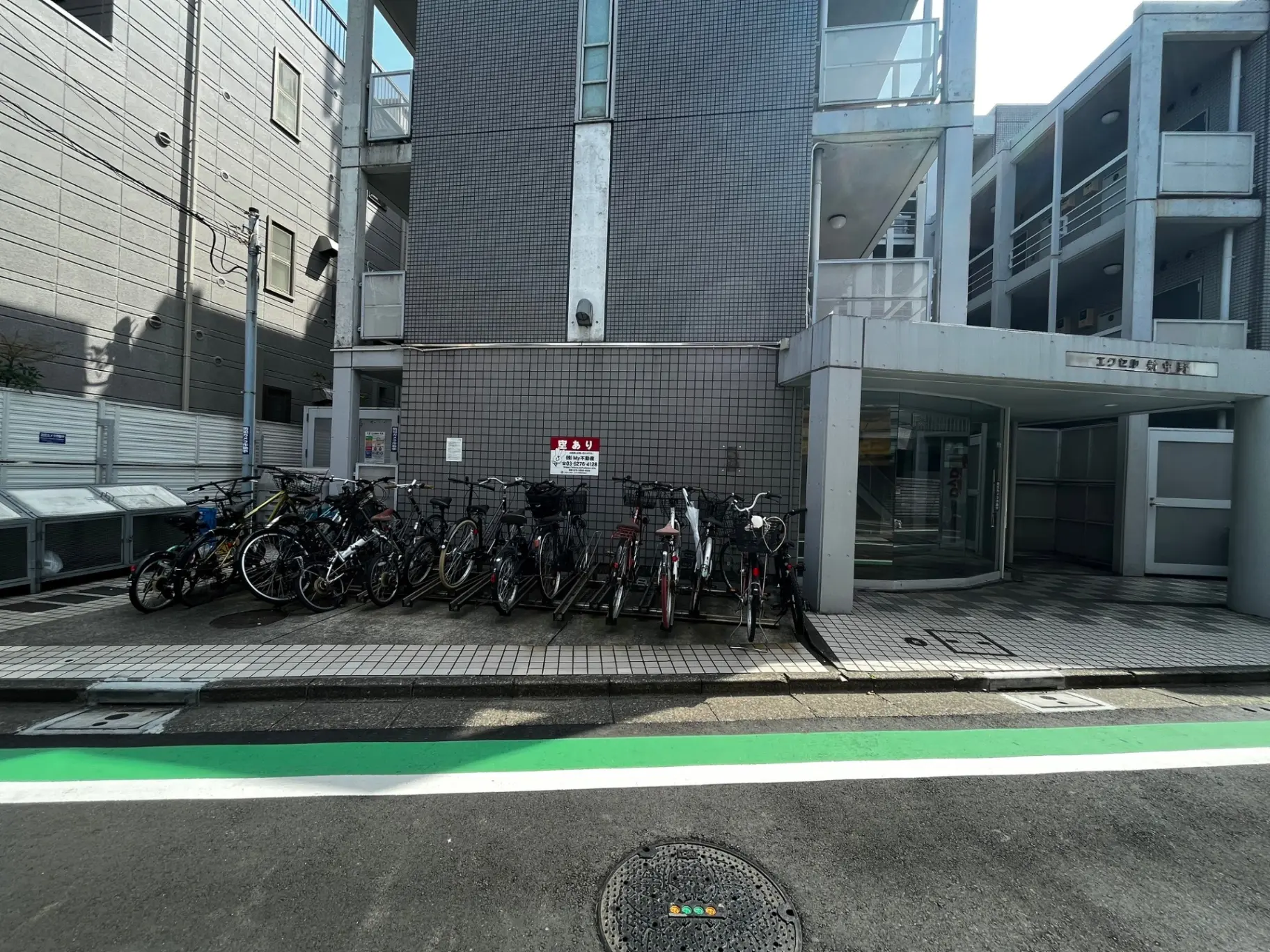 都市の自転車駐輪場、アパートのエントランスと清潔な歩道、日本の都会の風景