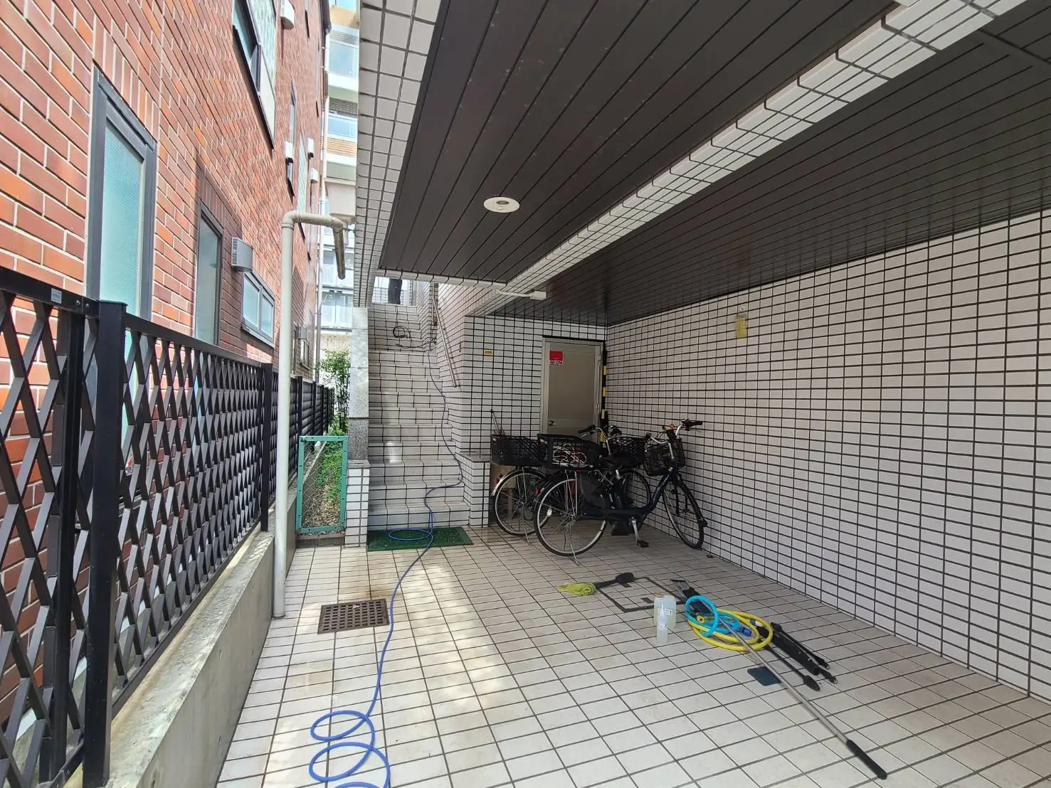 都市型マンションのタイル張りの駐輪場、自転車が設置されている屋根付きスペース