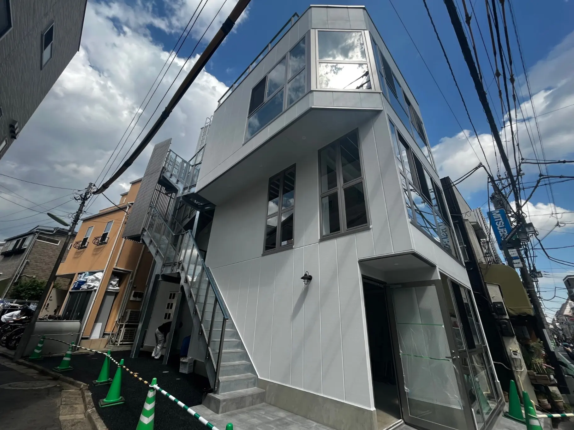 新築のモダンな都市型アパートメント、外階段付き、白い外壁と大きな窓のファサード