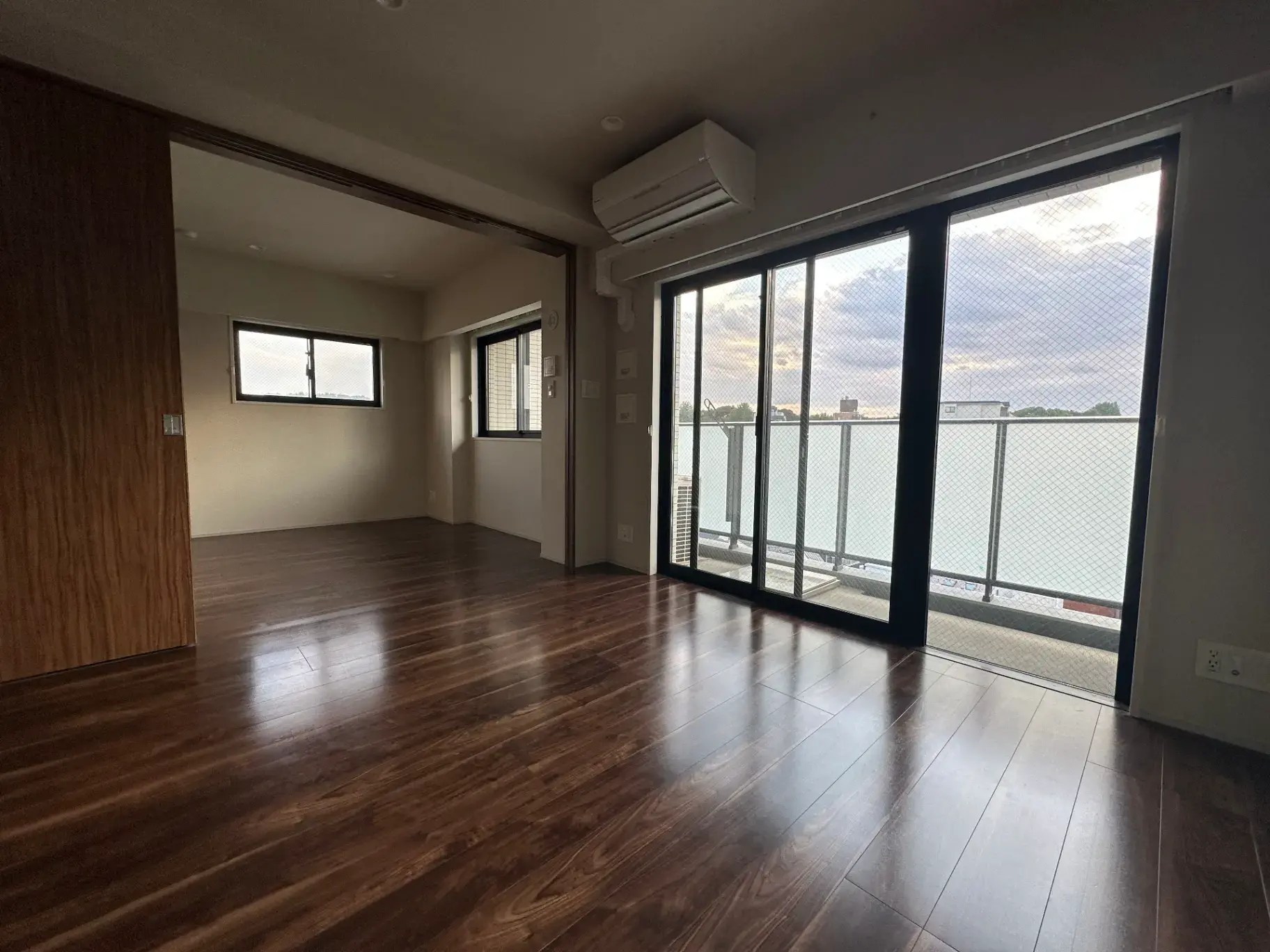 広々とした明るいリビングルーム、大きな窓とバルコニーからの眺望