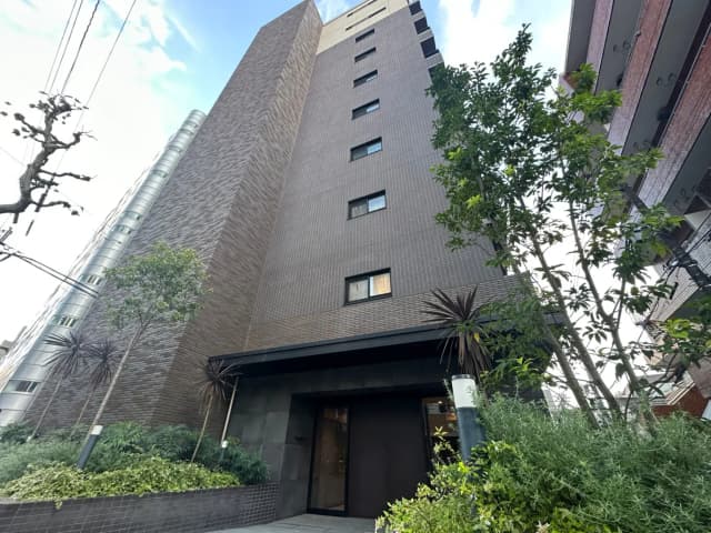 緑豊かな植栽に囲まれたモダンなビルのエントランス