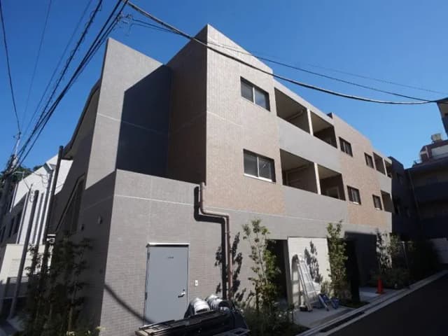 - モダンなアパートメントの外観、シンプルなデザインとテラス付き、青空の下での撮影