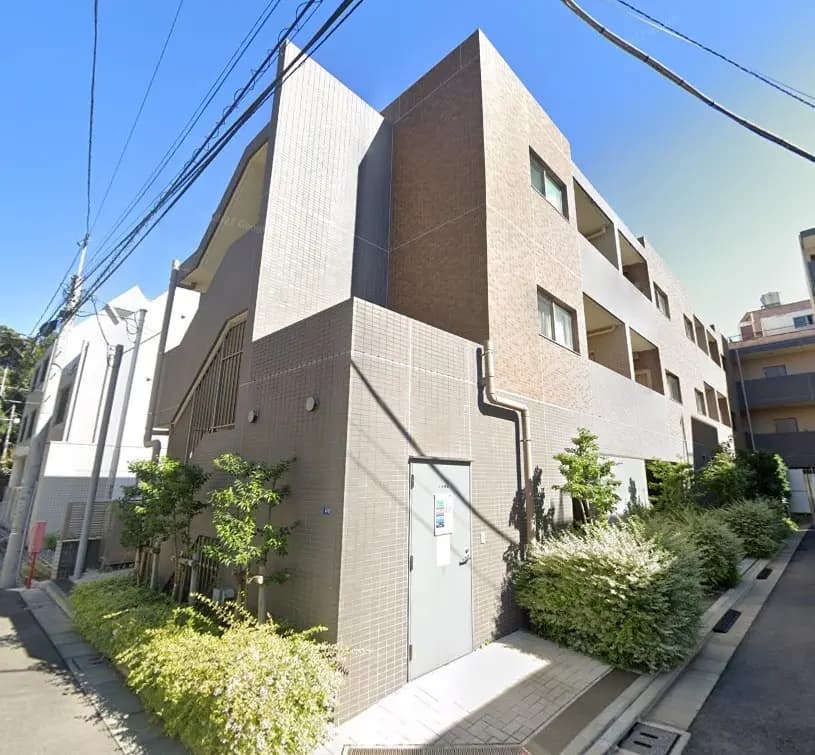 現代的な外観デザインのマンション、立体的な窓とエントランス、日当たり良好な住宅街