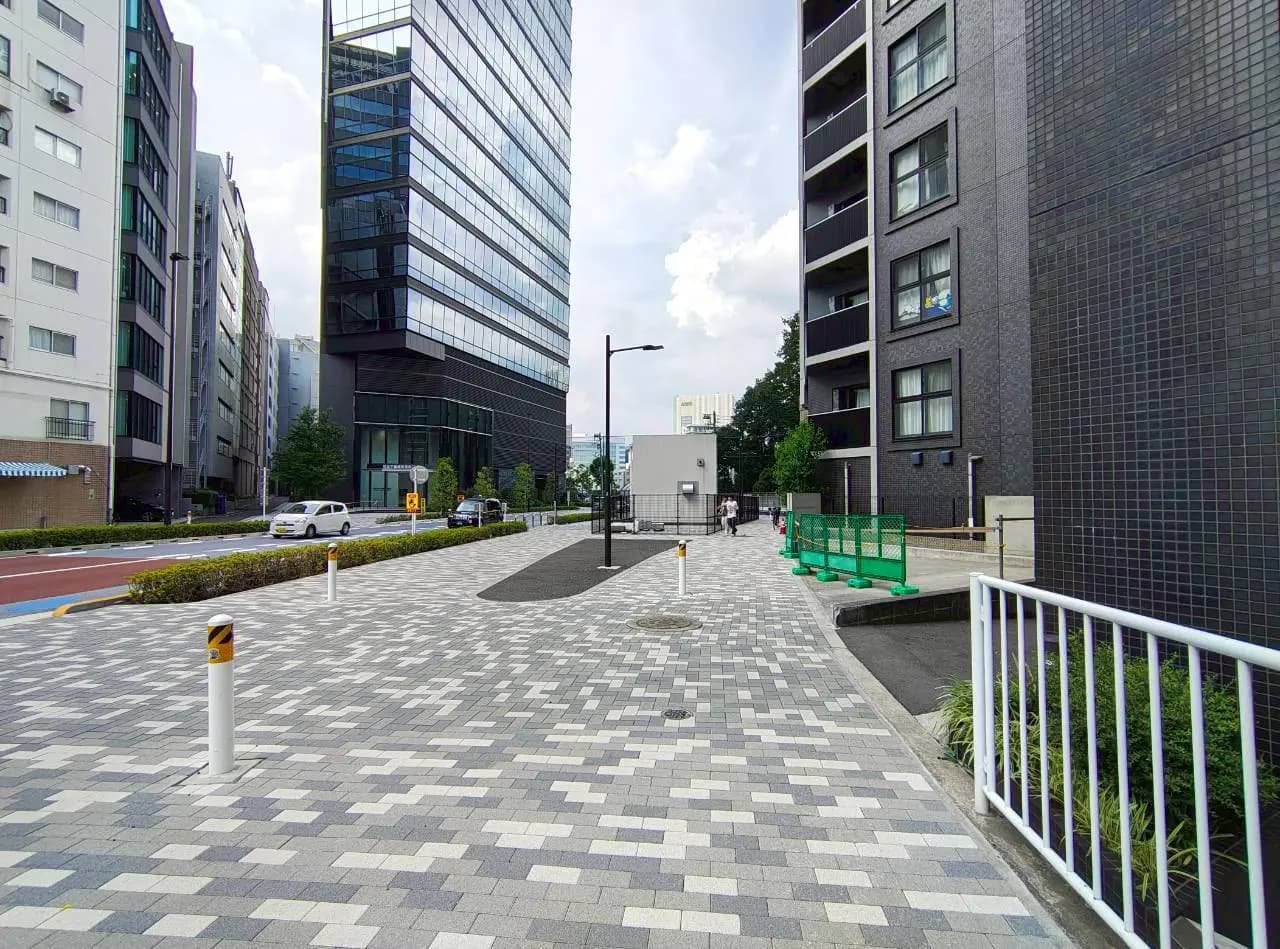 - 都市の風景、モダンな高層ビルが立ち並ぶ通り、石畳の歩道と街灯が配置された風景