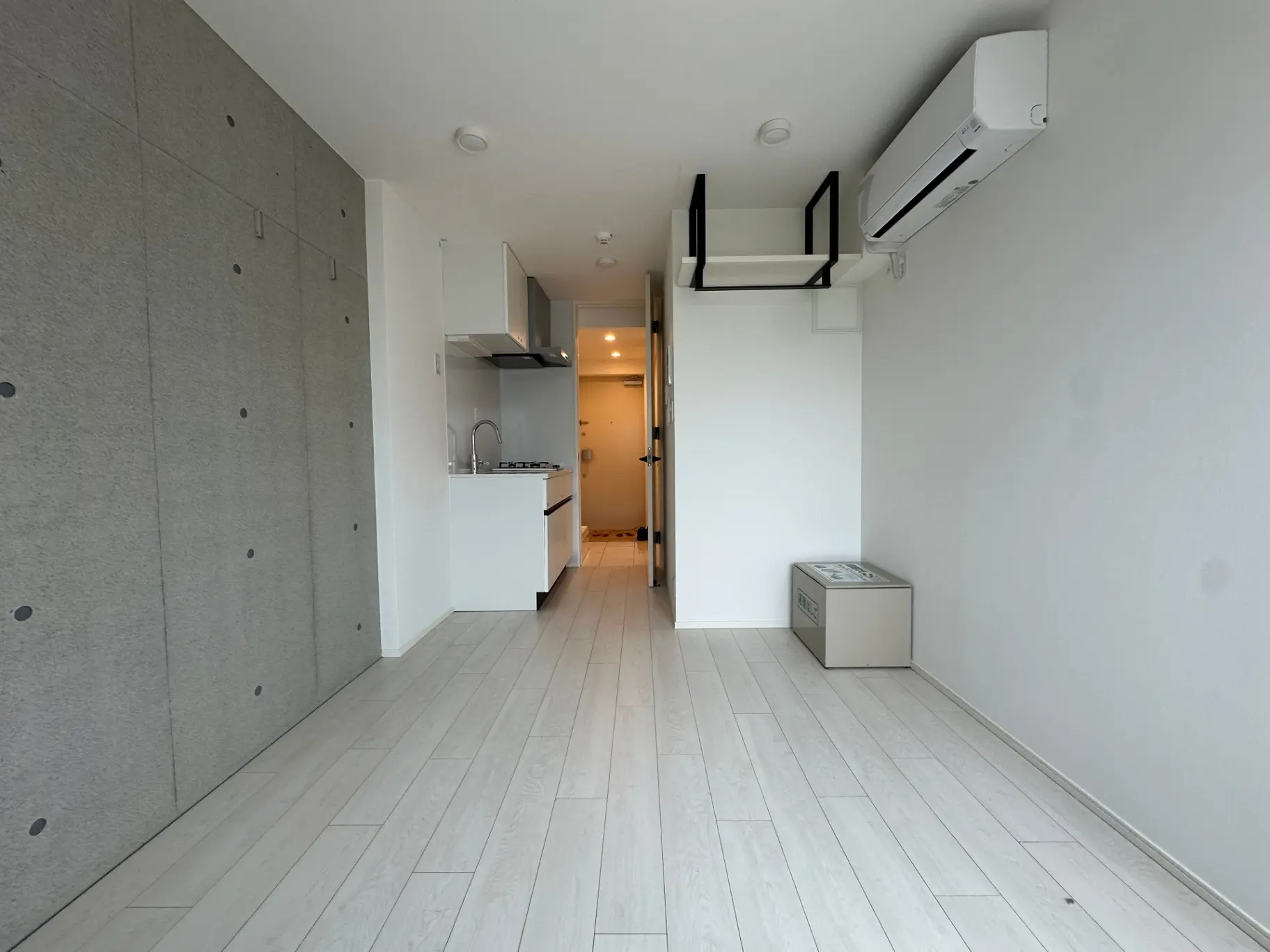シンプルで洗練されたデザインのワンルームマンション、白い床と壁、モダンなキッチン付き