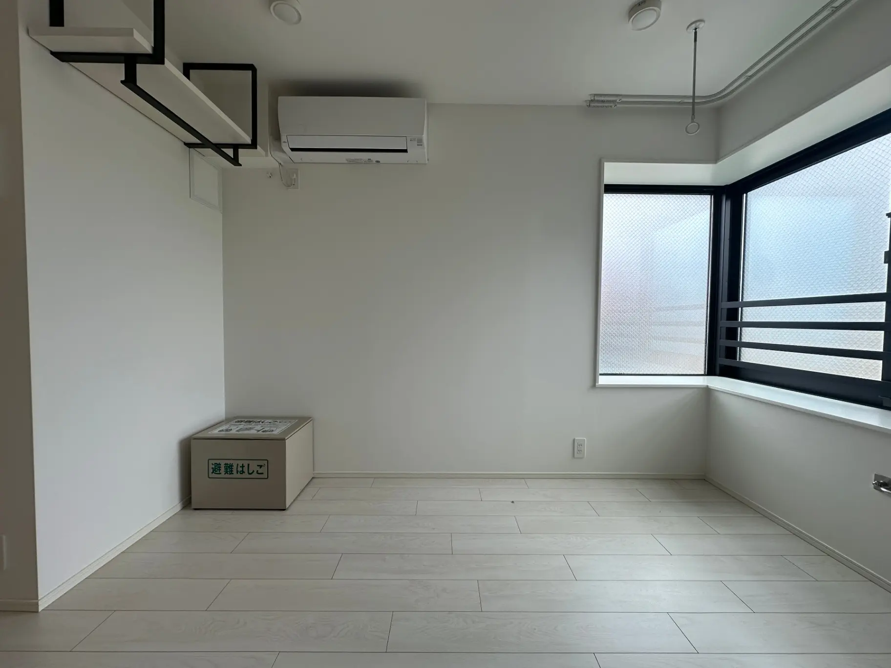 シンプルでモダンな新築マンションの居室、エアコンとバルコニー付き、自然光で明るい空間