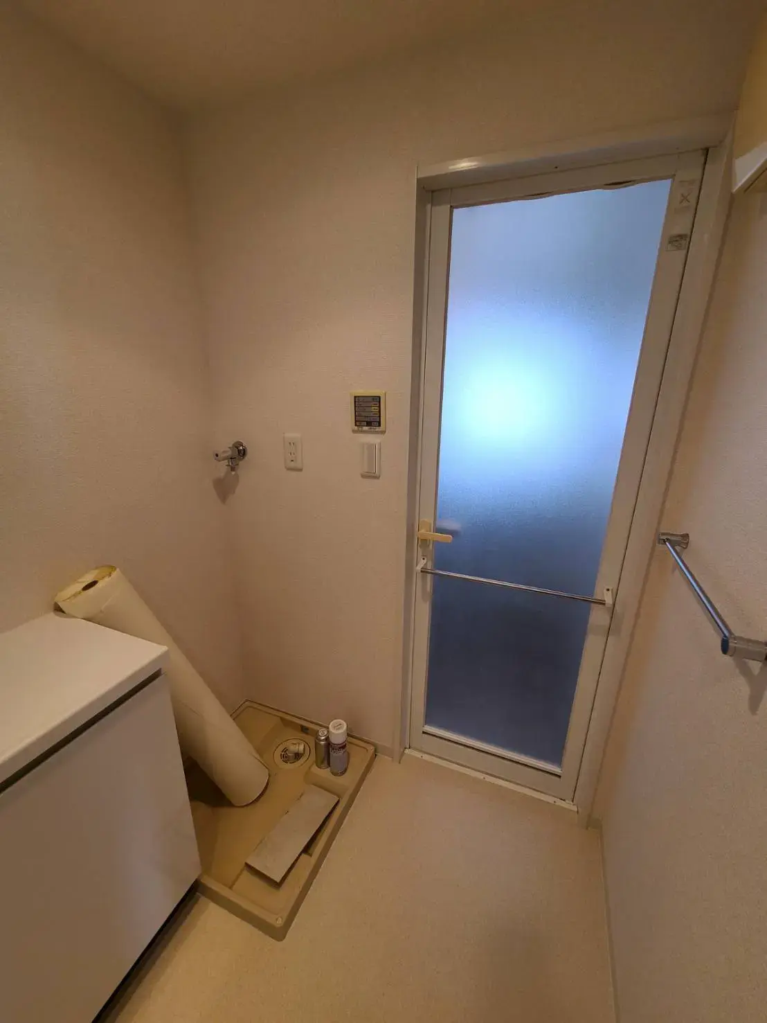 コンパクトな洗濯室、フロストガラスのドア、壁掛けの洗濯機、清潔感ある内装