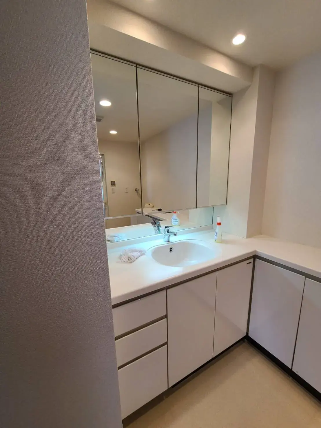 現代的なデザインのバスルーム、大きな鏡とシンク、クリーンな白い収納キャビネット