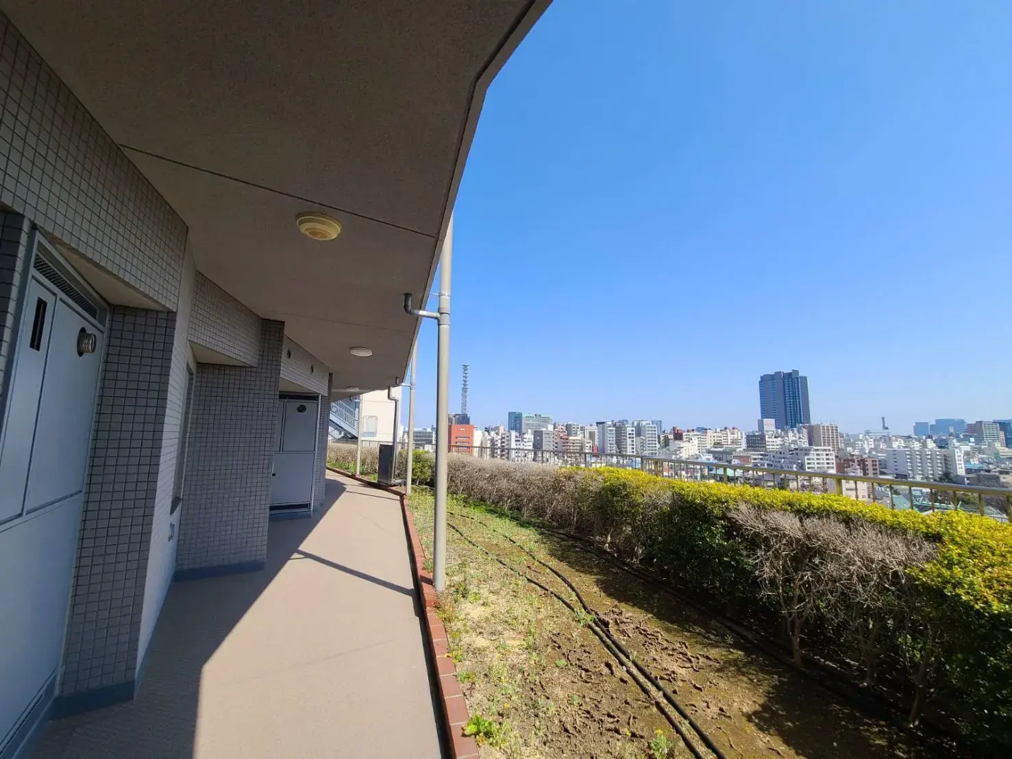 市街地の眺望を楽しめるアパートのバルコニー、晴れた日の都市風景