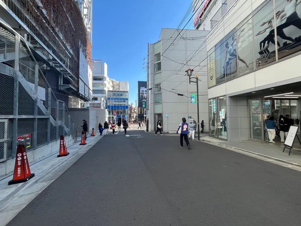 晴れた日の都市風景、歩行者とショップが並ぶ商店街、市街地の日常シーン