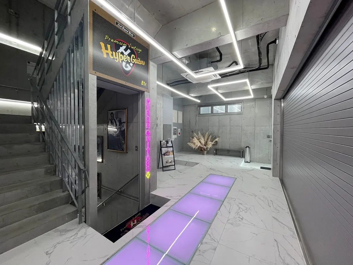 現代的な設計のギターショップの入口、階段とネオンサインが特徴的なインテリア