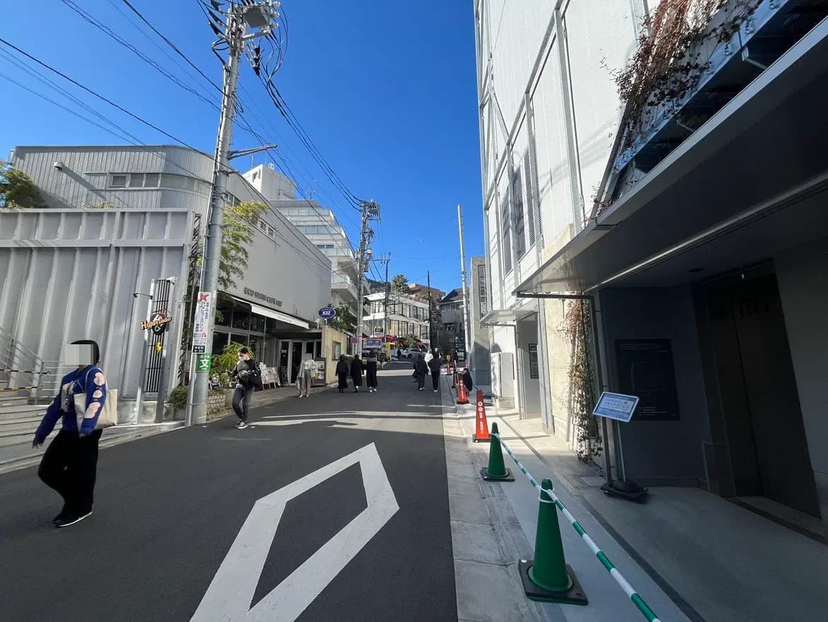 晴れた日の都市風景、道路標示と歩行者、商業施設の入口と現代的な建築デザイン