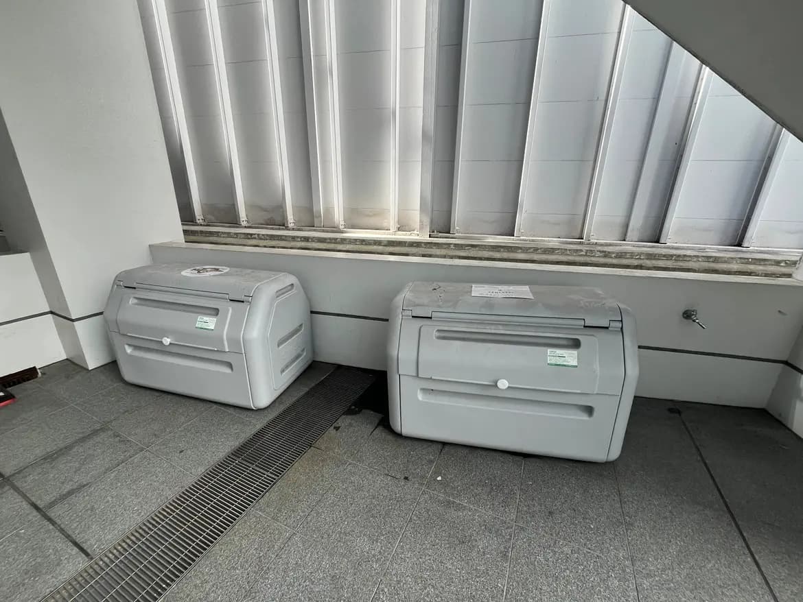 オフィスビルのエントランスに設置された二つのモノクロプリンタ、使用済みラベル付き