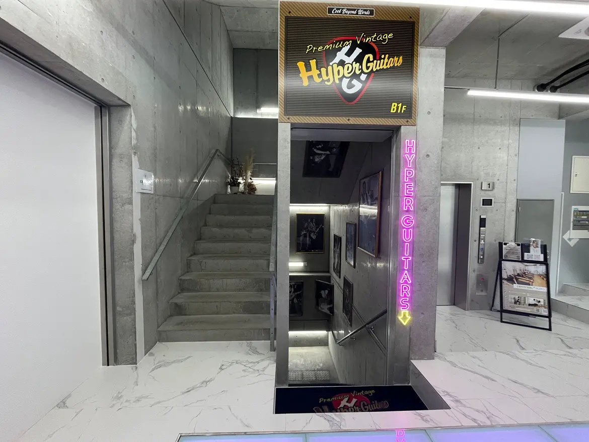 ヴィンテージギターショップの入り口と階段、ネオンサインの看板