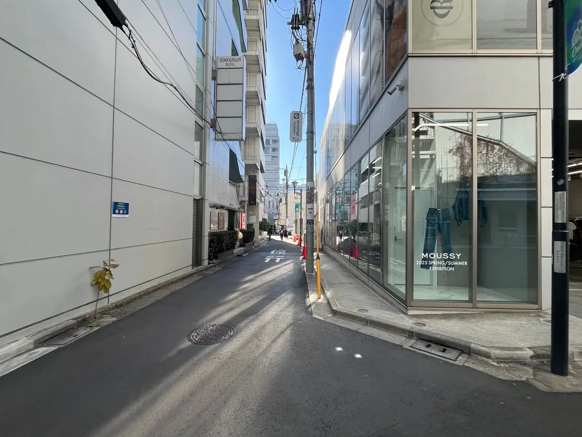 都市の日当たりの良い商店街、ガラス張りのファッションブティックの外観と静かな歩道