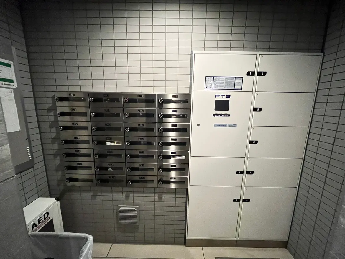 現代的なマンションのエントランスにある郵便受けと自動体外式除細動器(AED)キャビネット