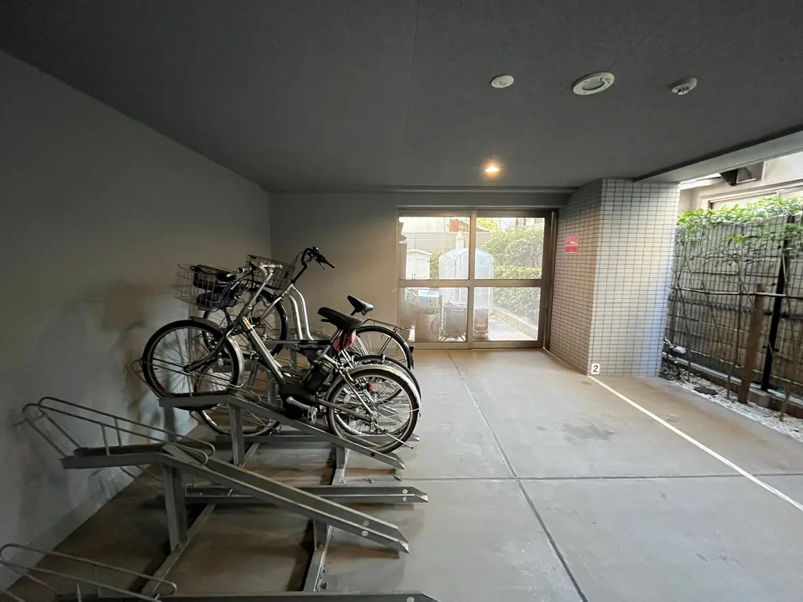 屋根付き自転車駐輪場、並べられた複数の自転車、都市型集合住宅の実用的な施設