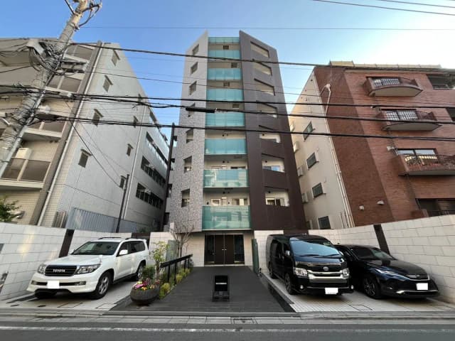 現代的なマンションの外観、駐車スペースに車２台、都市型住宅街の景観