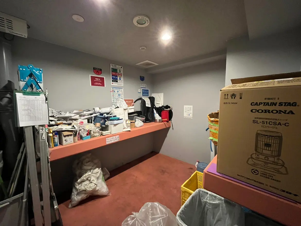 混雑した倉庫部屋、多様な物品と段ボールが積み上げられているインテリア