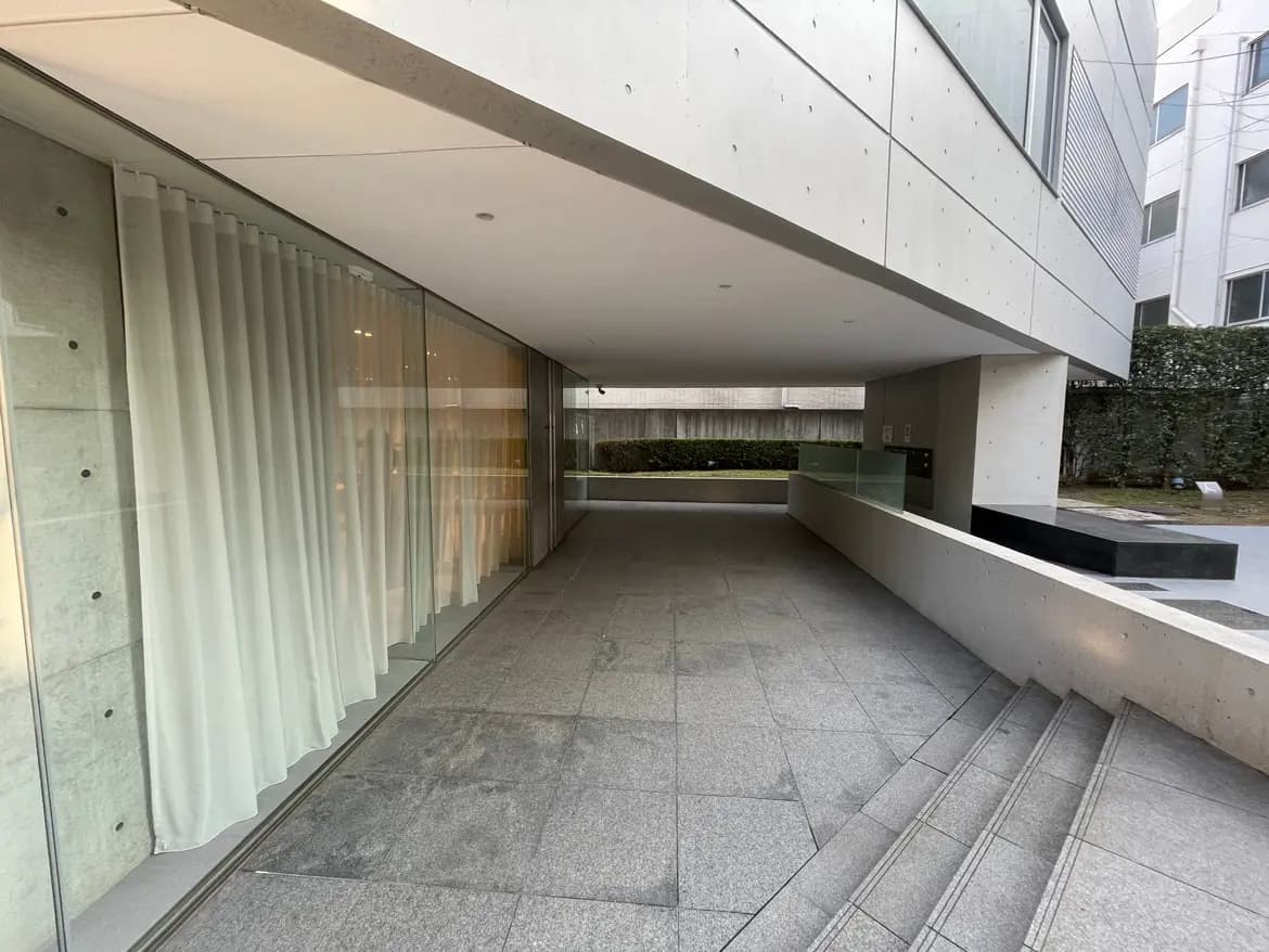 モダンな建築スタイルのエントランス、石の壁と床、ガラス窓と清掃が行き届いている空間