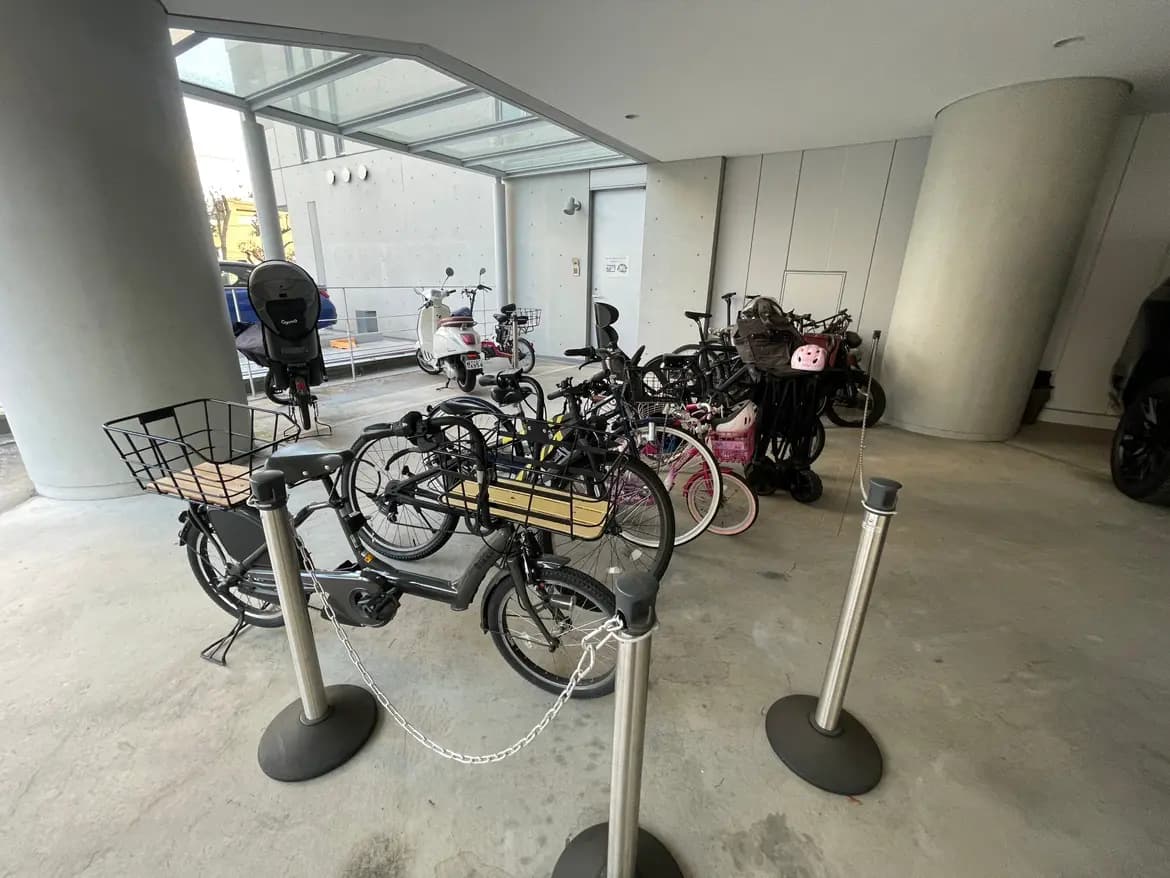 モダンな建物の自転車置き場、多様な自転車が整然と駐輪されているシーン
