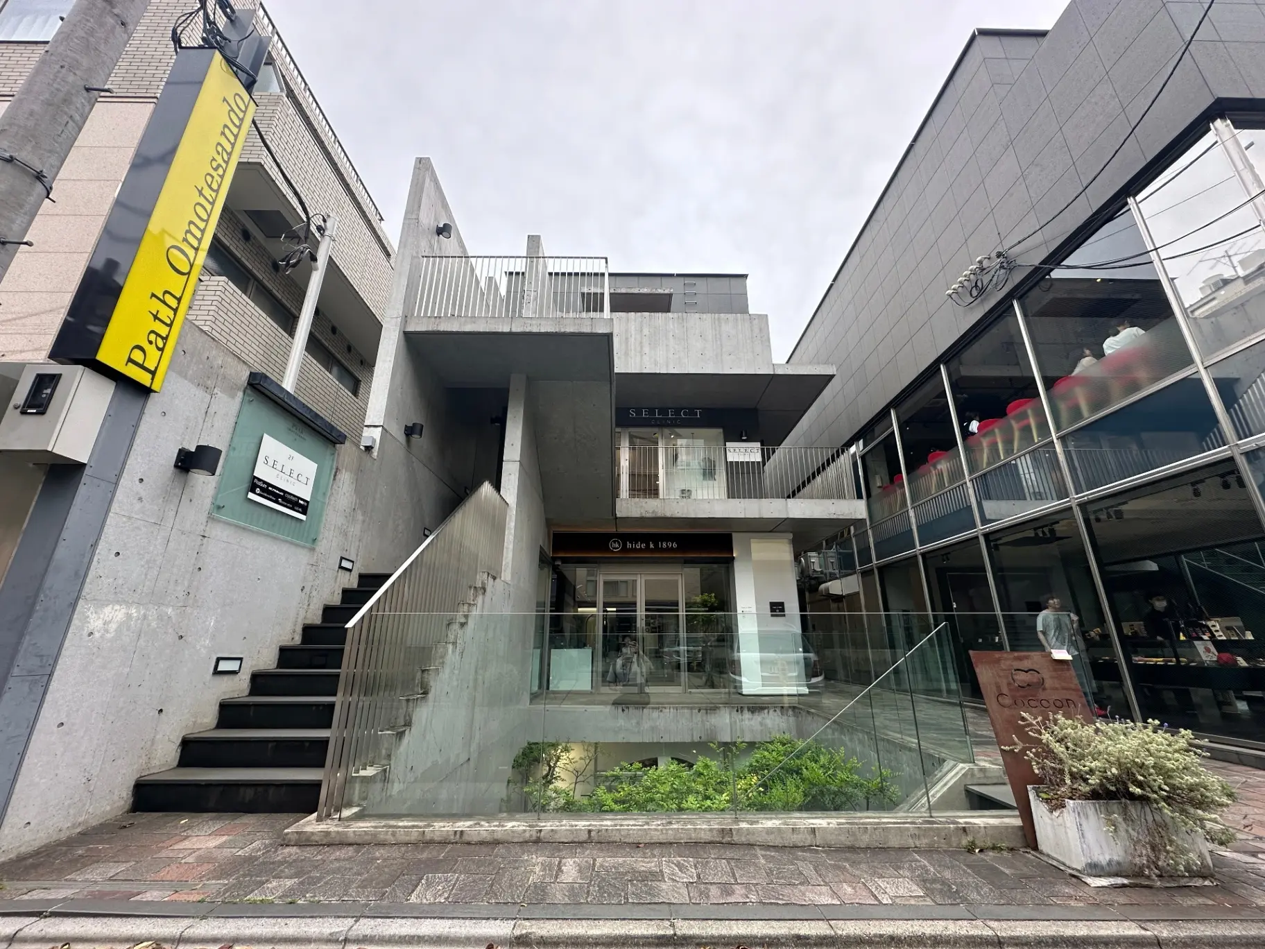 表参道にあるモダンな建築デザインのショッピングモール、ガラス張りのファサードと屋外階段が特徴