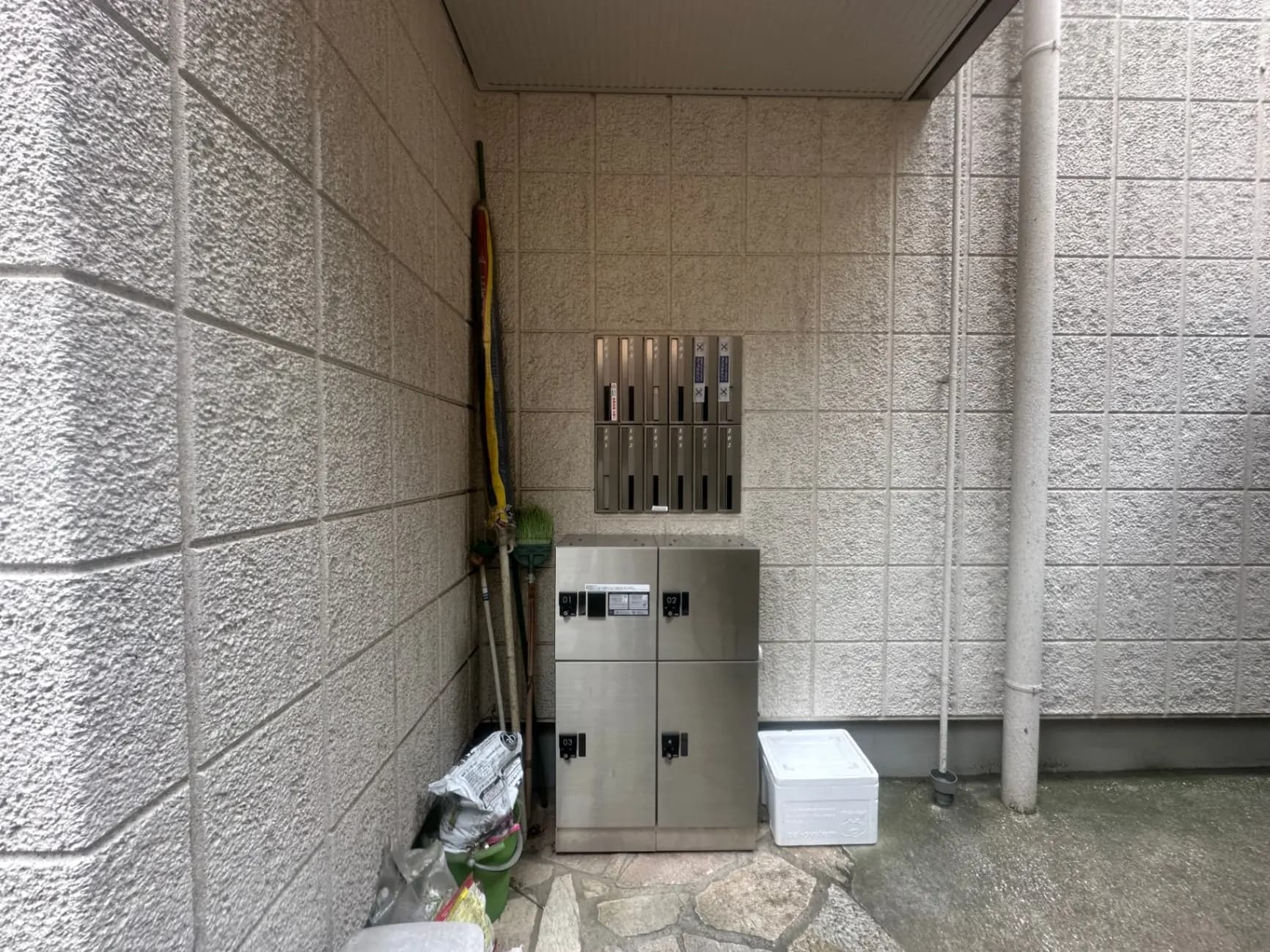 アパートメントの外壁と共用スペース、雨水排水管とステンレス製の郵便受けboxes