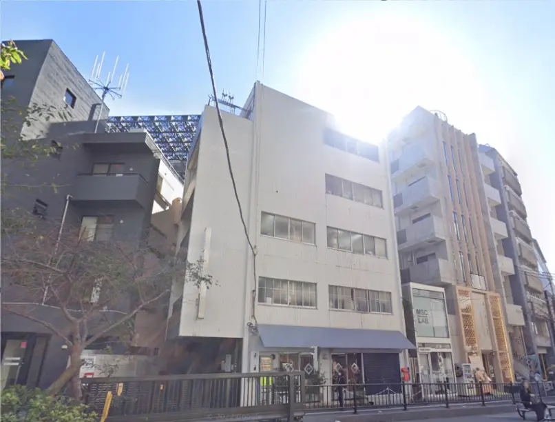 都心のビル街にあるオフィスビルと商業ビルの外観、日差しを浴びて明るい街並み